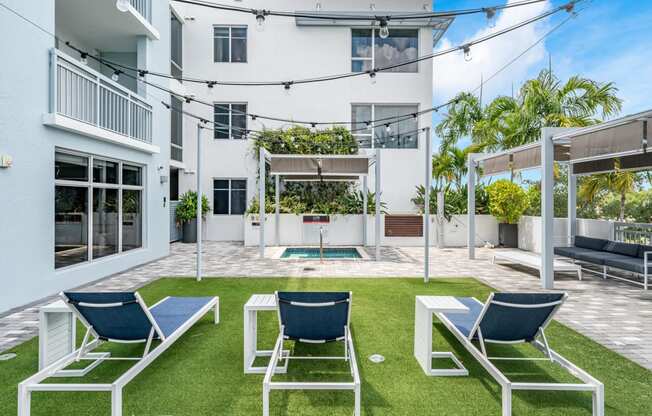 a backyard with lawn chairs and a pool