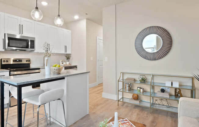 A modern kitchen with white cabinets and a black countertop.
