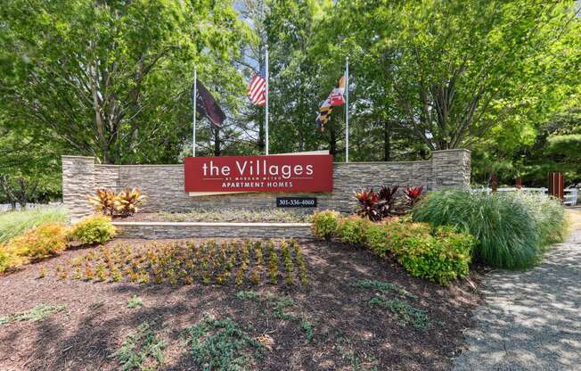 a sign for thevillages yards with flags and trees