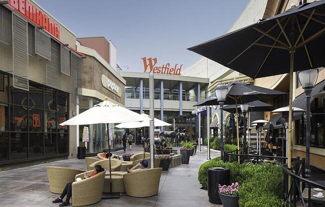 a person sitting on a couch under an umbrella