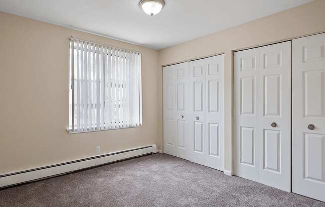 a bedroom with two closets and a window
