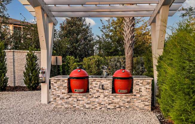 two red trash cans sitting on a brick wall under a roof