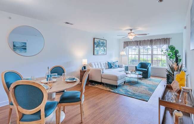 A dining room with blue chairs and a white couch.