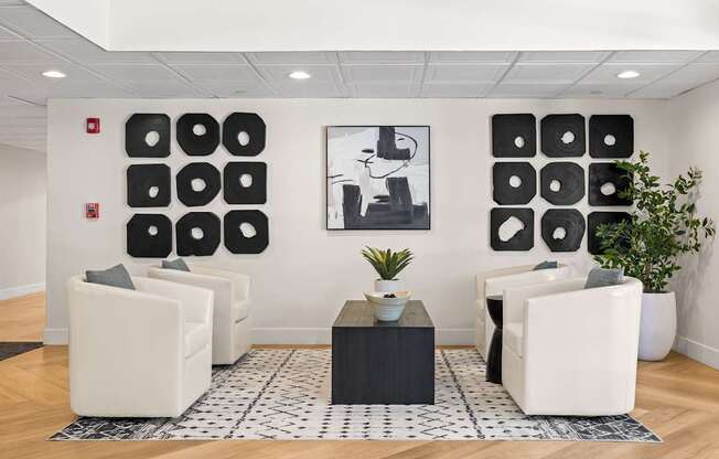 A black and white photo is on the wall above a black table.