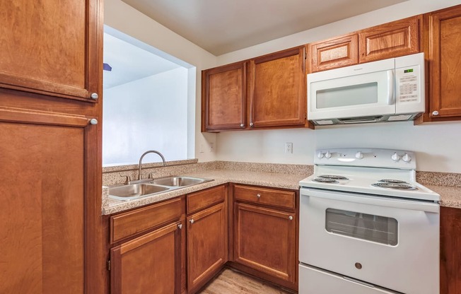 a kitchen with wooden cabinets and white appliances