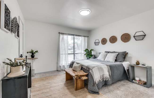 a bedroom with a bed and a dresser in front of a window