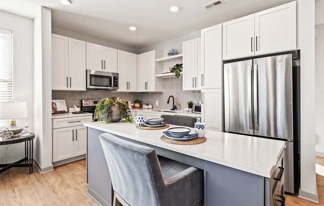 A kitchen with a white countertop and a grey chair