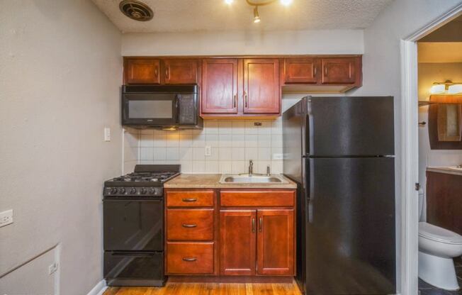 Rich wood cabinetry and tiled backsplash in the kitchen