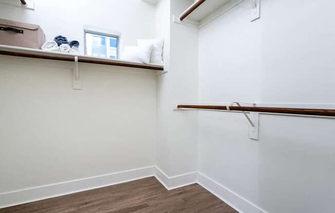 A room with a window and a shelf with a few items on it.