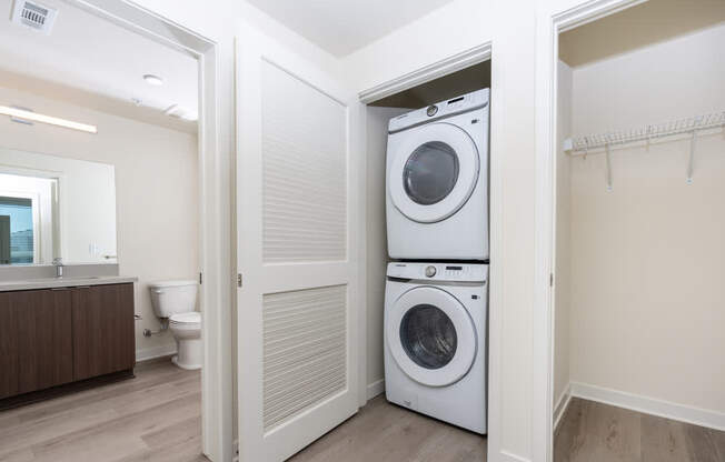 A white washer and dryer are stacked on top of each other in a laundry room.