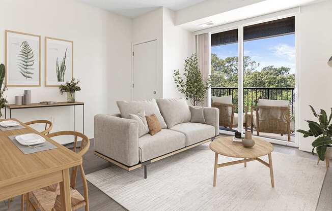 A living room with a grey couch, a wooden table, and a sliding glass door.