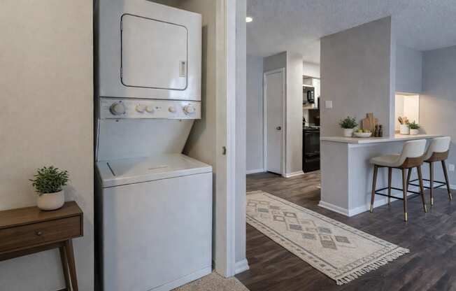 A modern kitchen with a white oven and a bar area with stools.