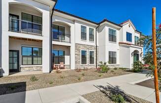 an exterior view of three buildings with a sidewalk in front of them at Stella, San Tan Valley, AZ
