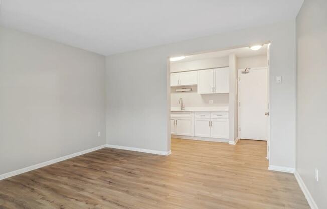 A room with wooden flooring and white walls.