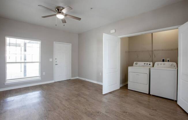 A room with a ceiling fan and a washer and dryer.