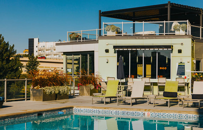 a swimming pool with chairs next to a poolside building