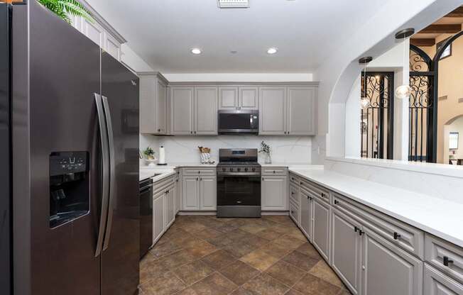 A modern kitchen with a refrigerator on the left and a stove on the right.