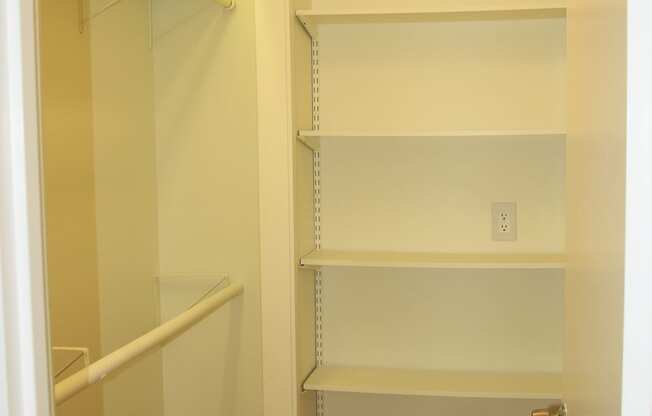 a walk in closet with shelves and a closet door openat Renew Worcester, Worcester, MA