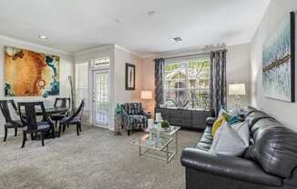 a living room with a couch and a chair in front of a table with a chair and