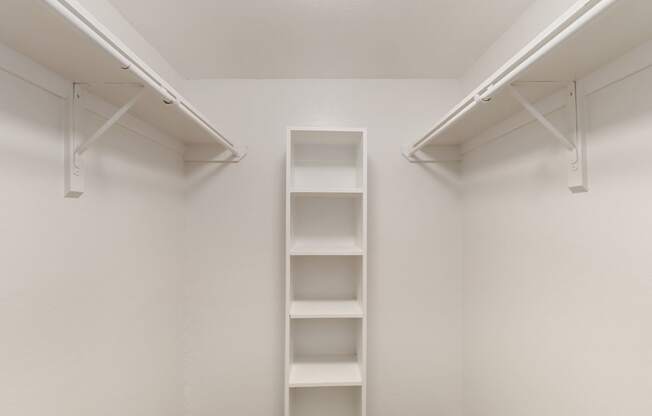 a walk in closet with empty shelves