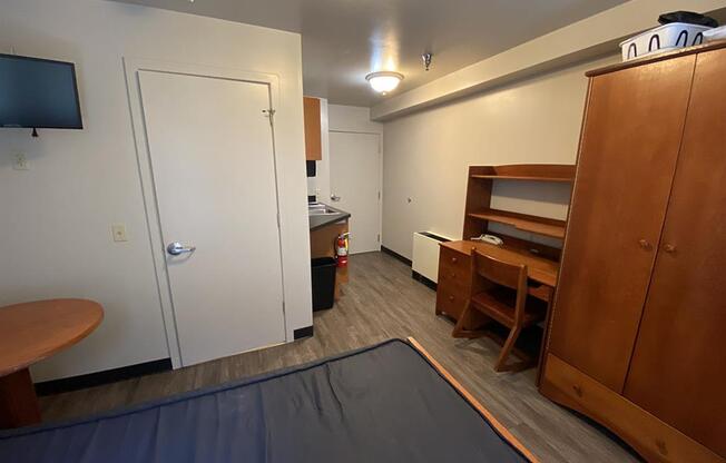 a room with a bed and a desk and a door