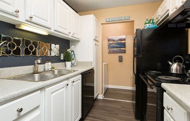 a kitchen with a sink and a black refrigerator