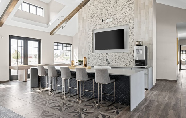 a kitchen with bar stools and a tv on the wall