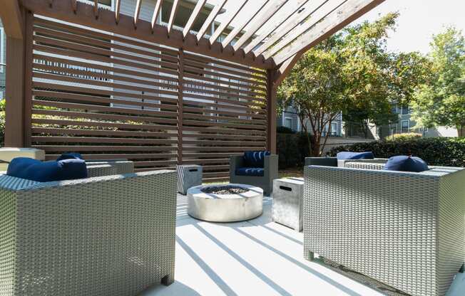 a covered patio with chairs and a fire pit