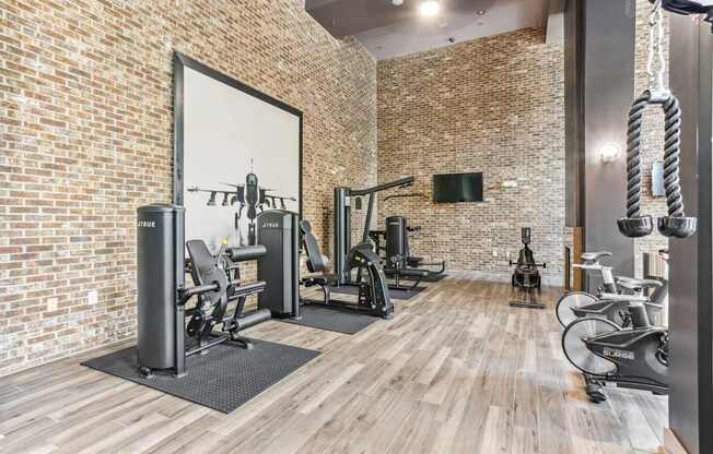 A gym with a brick wall and wooden floors.