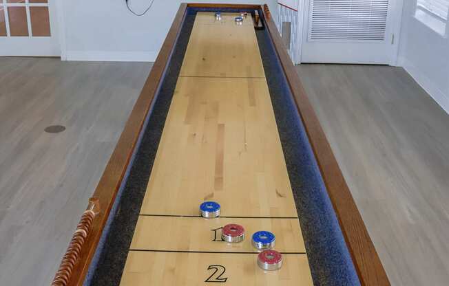 a shuffleboard table in a living room with a tv