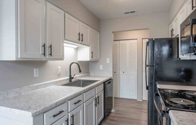 a kitchen with marble counter tops and white cabinets