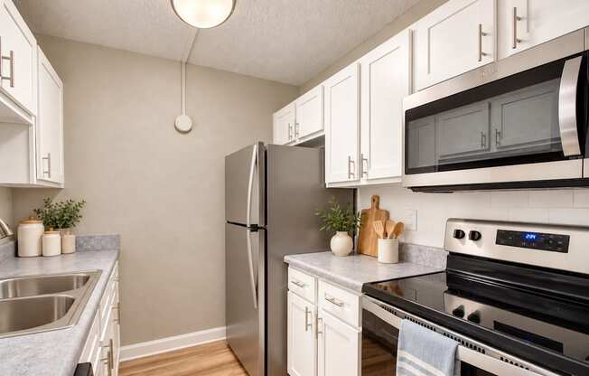 Galley kitchen with white cabinets and a refrigerator at Waterchase Apartments in Largo, FL.
