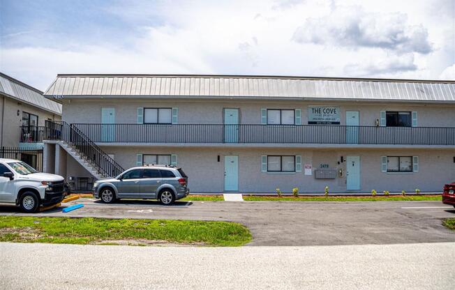 a building with a parking lot and cars in front of it