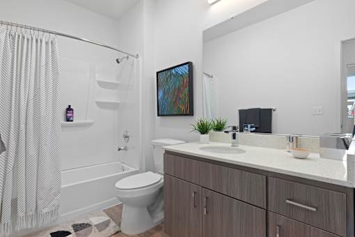 A bathroom with a toilet, sink, and shower.