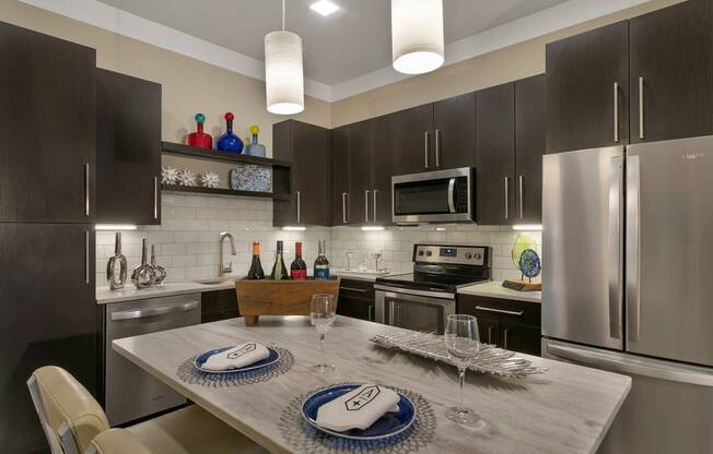 a kitchen with stainless steel appliances and a dining table at Aster Apartments, Ohio, 44122