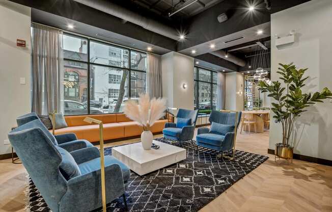 a lounge area with blue chairs and a white coffee table