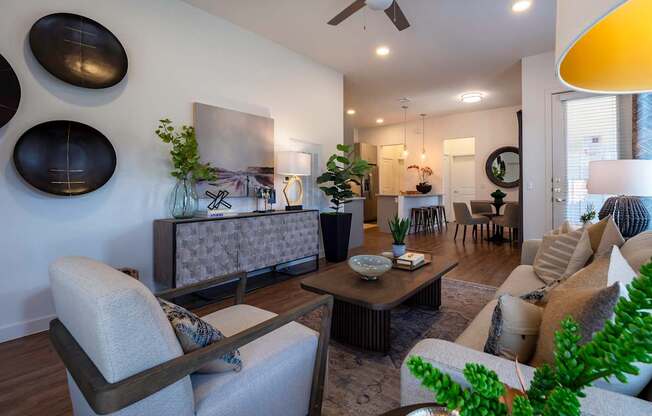 A living room with a grey sofa, a wooden coffee table, and a ceiling fan.