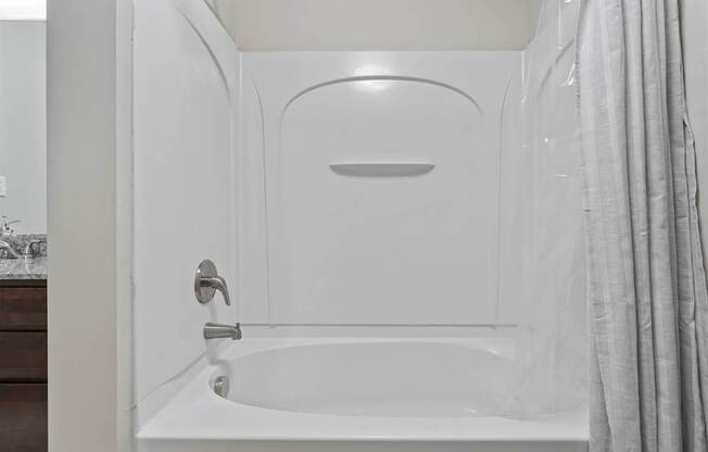 A white bathroom with a tub and a shower.