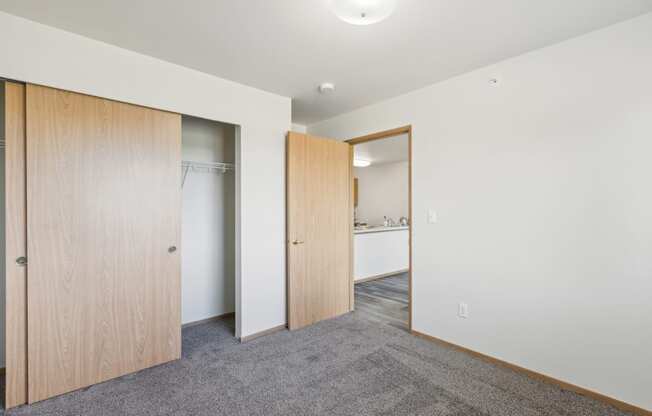 a bedroom with a door to a closet and a bathroom