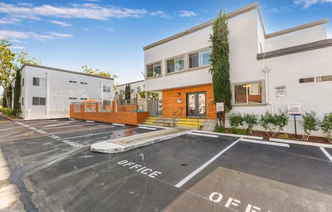 a large white building with a parking lot in front of it