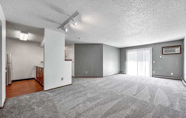 the living room is empty of furniture and has a sliding glass door
