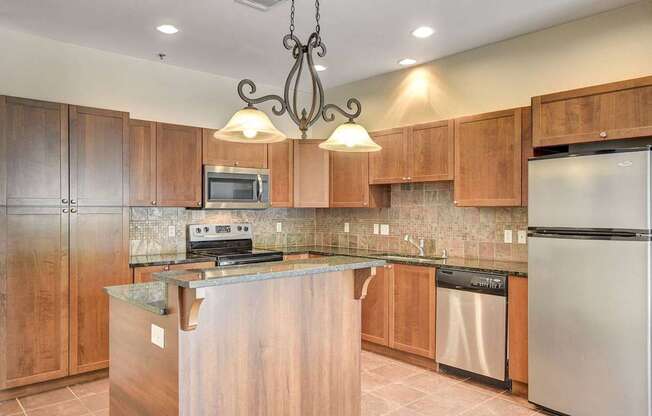 A kitchen with wooden cabinets and a granite countertop.