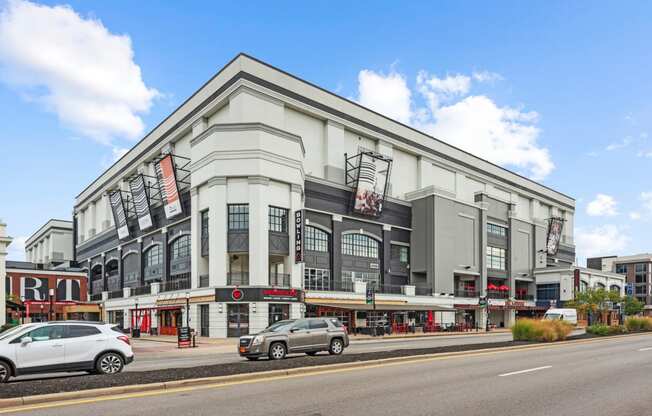 a large building with cars parked outside of it on a city street