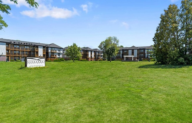 a grassy area with buildings in the background