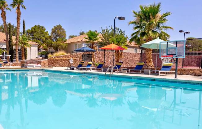 a swimming pool with chairs and umbrellas at a resort