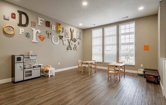 a playroom with a table and chairs and a stove