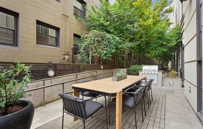 the outdoor patio has a table and chairs and a grill