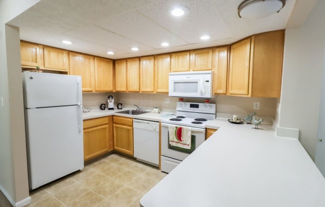 a kitchen with white appliances and wooden cabinets