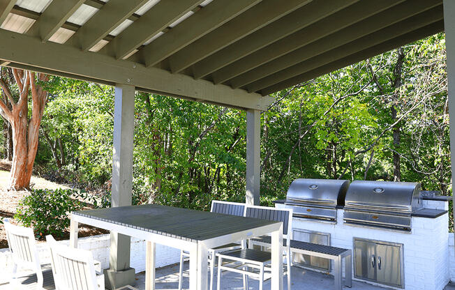 a patio with a table and chairs under a roof