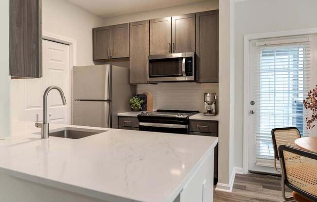 A kitchen with a white counter top and a sink.